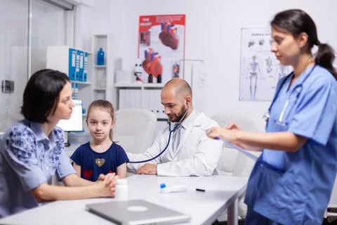 Doctor pediatry checking evolution of flu using stethoscope 写真素材