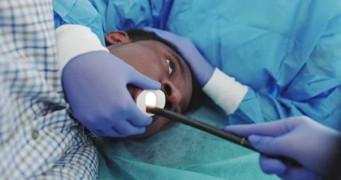 The Doctor Performs Endoscopy Through The Mouth Of A Young African-American Guy Stock Footage 148228353