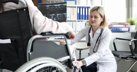 Doctor performs knee reflex test on patient in wheelchair Stock Footage 312157419