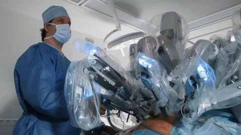 Doctor performs operation using medical robotic surgical Da Vinci system Stock Footage 242165671
