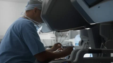 Doctor performs surgery on modern robotic medical equipment in operating room Stock Footage 242367642