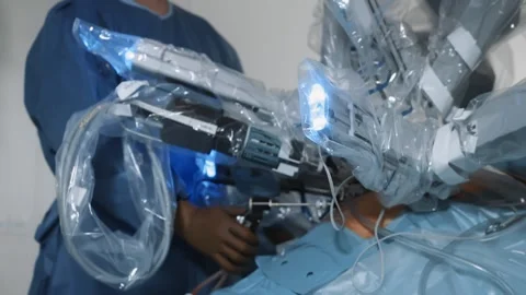 Doctor performs surgery on patient using sterile medical robot in modern clinic Stock Footage 245699205