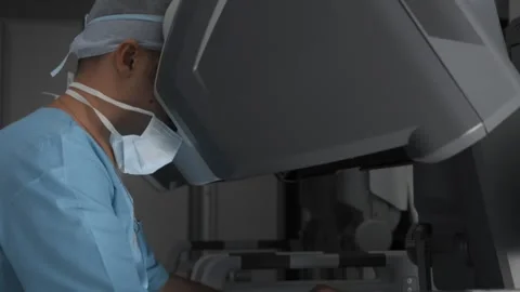 Doctor performs surgery using medical robot in advanced operating room. Stock Footage 241228126