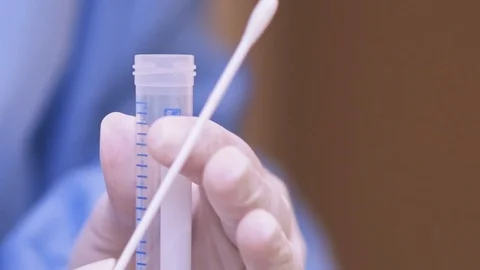 Doctor places a COVID-19 test swab into a swab tube, extreme close up shot. Stock Footage