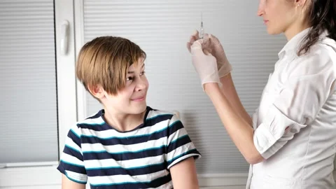 Doctor preparing to do injection to boy arm Stock Footage 147210972