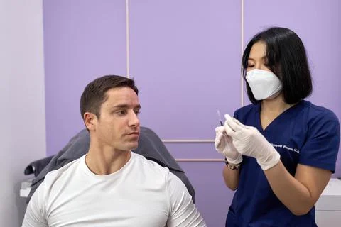 Doctor preparing the injection she will use on a patient for a beauty treatment. Stock Photos