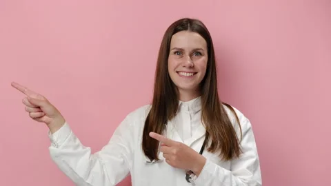 Doctor presenting and showing something isolated on pink studio background wall Stock Footage 155688493