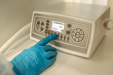 The doctor presses a button on a pedicure machine. Stock Photos