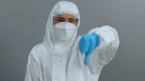 Doctor in protective PPE suit doing thump down hand sign Stock Footage 166905850