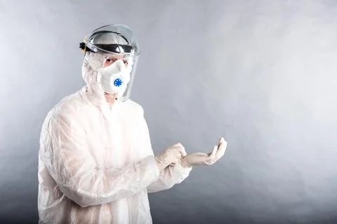 A doctor in a protective PPE suit shows how to use it in the fight against th Stock Photos