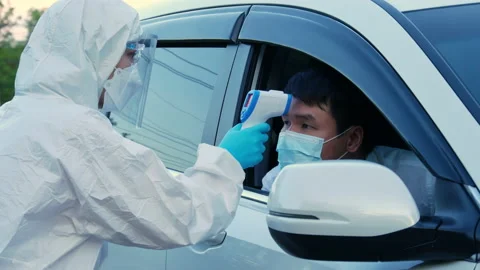 Doctor in protective PPE suit using infrared thermometer measuring temperature  Stock Footage 166907523