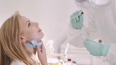 A doctor in a protective suit taking a nasal swab from a person to test for Stock Footage 145694341