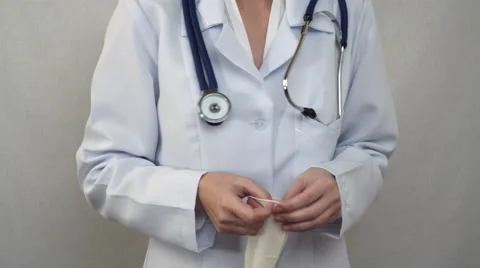 Doctor pulling on rubber gloves 59100380