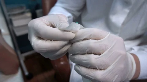 The doctor pulls out the syringe from the packaging Stock Footage 77202604