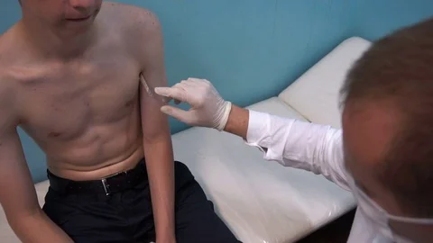 The doctor pulls out a thermometer and watching the temperature of the patient Video stock 77203068