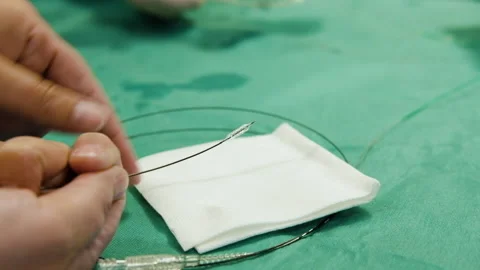 Doctor pulls off stent from small balloon, inspecting the tiny metal Stock Footage 133532864