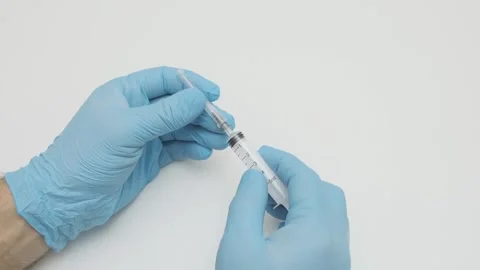 Doctor put an injection needle on plastic disposable syringe Stock-Footage 265878898
