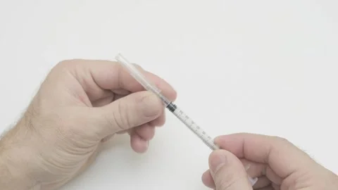 Doctor puts thin needle on an insulin syringe Stock Footage 279024903