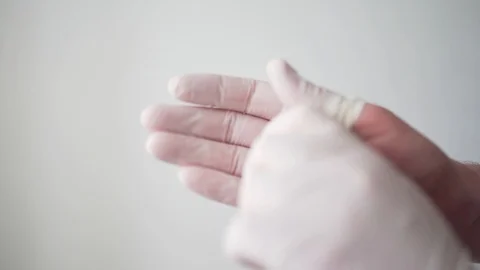 The doctor puts white protective gloves on his hands. A professional medical Stock Footage 126970151