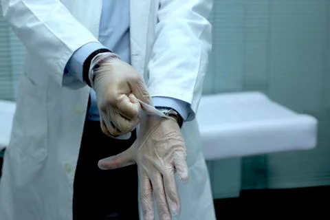 Doctor putting on nitrite gloves close up Stock Photos