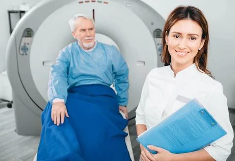 Doctor radiologist, smiling while looking at camera. Behind her sitting sen.. Foto stock
