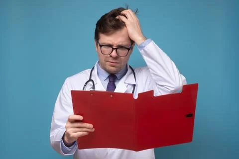 Doctor reading some notes trying to make a correct diagnosis on data Stock Photos