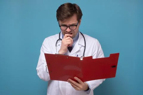 Doctor reading some notes trying to make a correct diagnosis on data Stock Photos