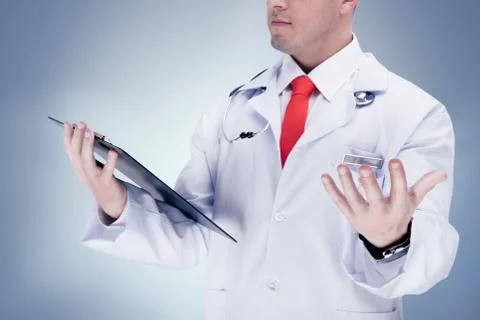 Doctor with a red tie holding a tablet . High resolution. Stock Photos