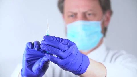 Doctor removing air bubbles from injection solution in a syringe Stock Footage 147221759