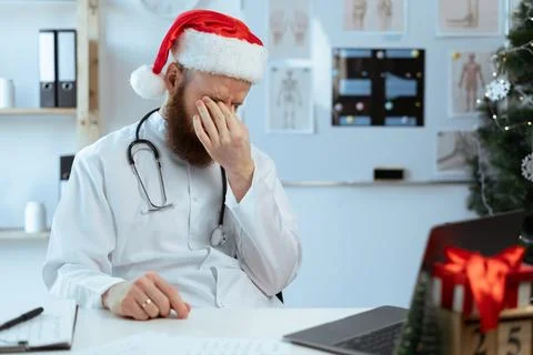 Doctor on the shift working on laptop computer suffering eyes ache and eyestrain Stock Photos