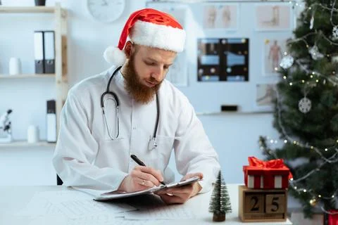 Doctor on the shift writing notes on clipboard for hospital schedule on Stock Photos