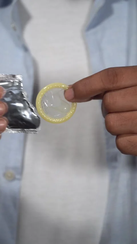 Doctor showing condom removing from wrapper Stock Footage 314384605
