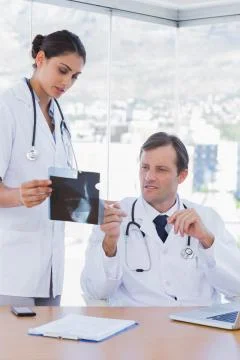 Doctor showing a x ray to a colleague Stock Photos