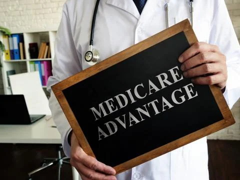 A Doctor shows a tablet Medicare advantage. Stock Photos