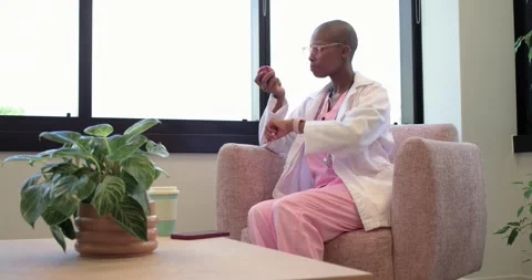 Doctor sitting by window checking phone placing phone on table checking watch Stock Footage 340010901