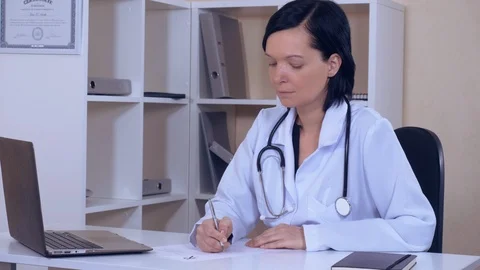 Doctor sitting at the workplace in office Stock Footage 86417425