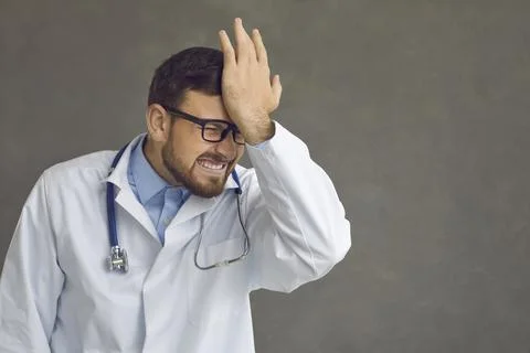 Doctor slaps his forehead as he remembers his stupid mistake and professional Stock Photos