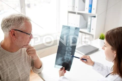 Doctor with spine x-ray and senior man at hospital Stock Photos