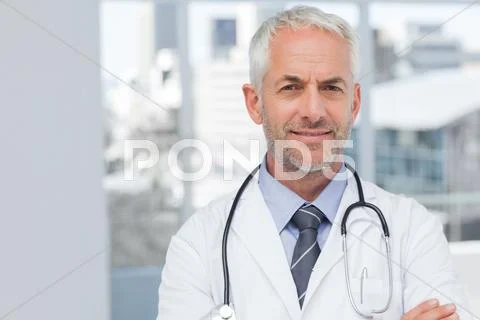 Doctor standing with arms folded Stock Photos