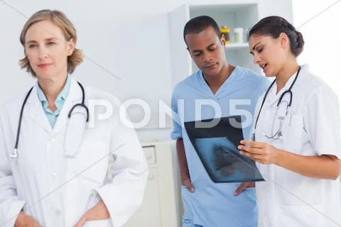 Doctor standing in front of medical team Stock Photos