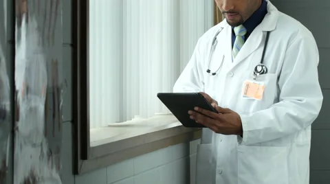 Doctor standing, using ipad/tablet Stock Footage 55853752