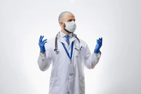 A doctor with a stethoscope in disposable gloves preparing to examine a patie Stock Photos