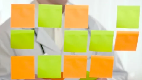 A doctor studies notes on colored green and orange stickers. Stock Footage 173602978