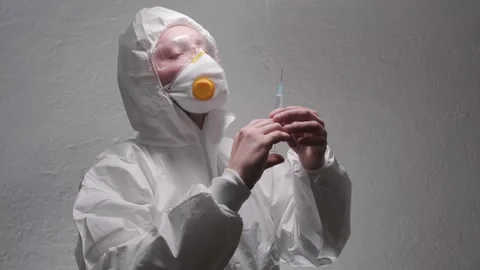Doctor with a syringe in personal protective who is preparing for vaccination Stock Footage
