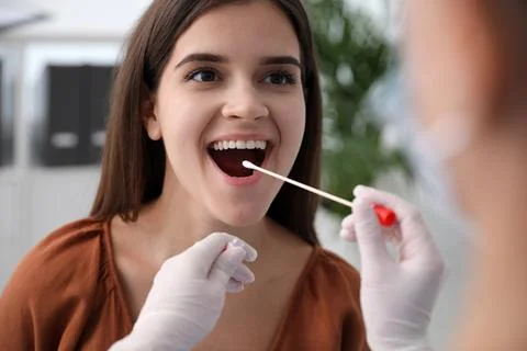 Doctor taking sample for DNA test from woman in clinic Stock Photos