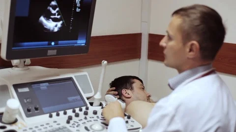 Doctor taking a sonogram and looking on the screen of ultrasound device. Stock Footage 76880025