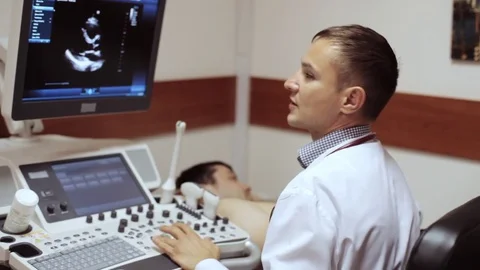 Doctor taking a sonogram and looking on the screen of ultrasound device. Stock Footage 76881273
