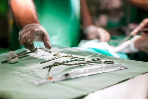 Doctor taking surgery tools from the table Stock Photos