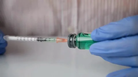 Doctor taking syringe preparing for the injection of syringe from an ampoule Видео 336586895