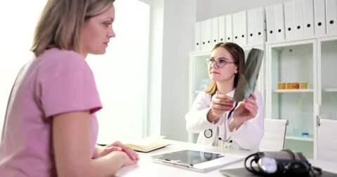 Doctor is talking and looking at x-ray film with picture of lungs Stock Footage 256292851
